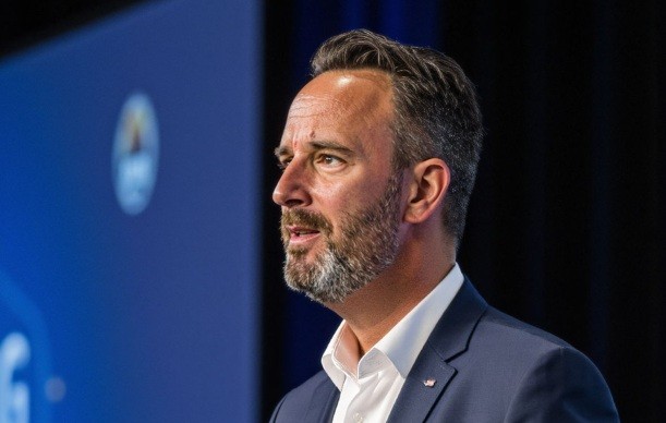 Mann im Anzug im Profil vor blauem Hintergrund