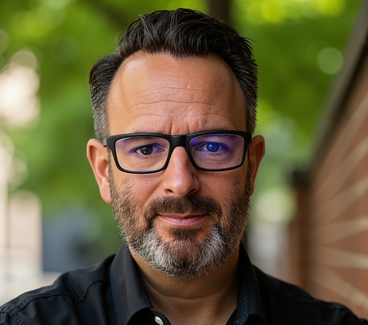 Mann mit Brille vor einem grünen Hintergrund